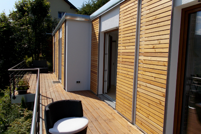 Holzhaus mit Terrasse, am Hang gelegen: Ein Modulhaus kann äußerst flexibel und an die Umgebung angepasst gestaltet werden.